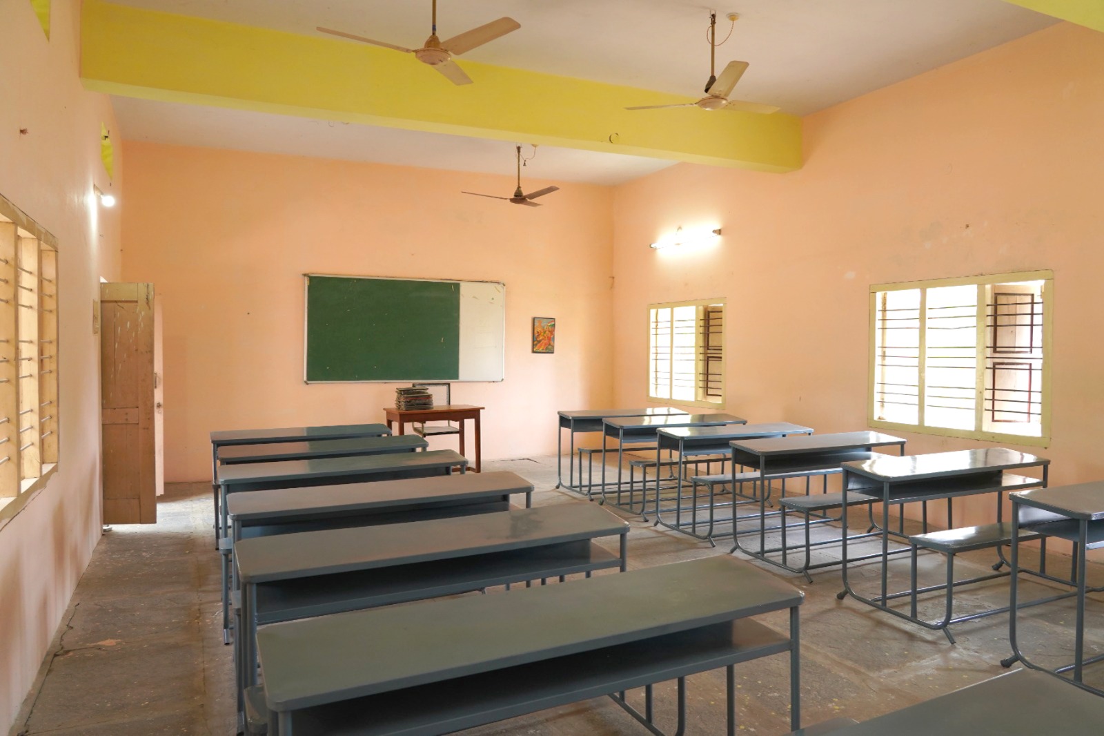 SEICOM classroom with desks, benches and a chalkboard